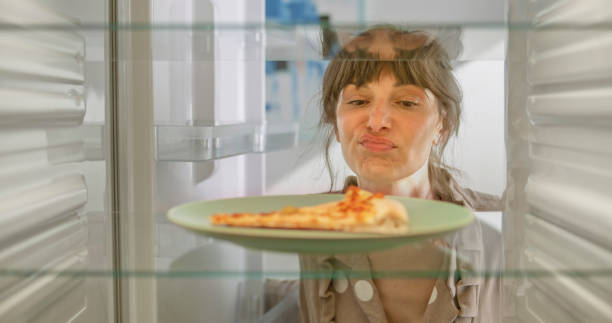 istock Frowning woman looking slice of pizza 2022573461