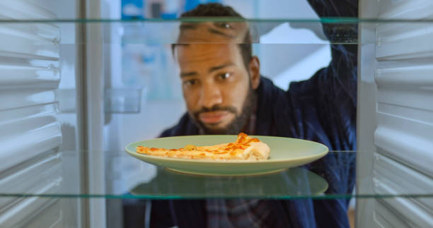 istock Frowning man looking slice of pizza 2022573496