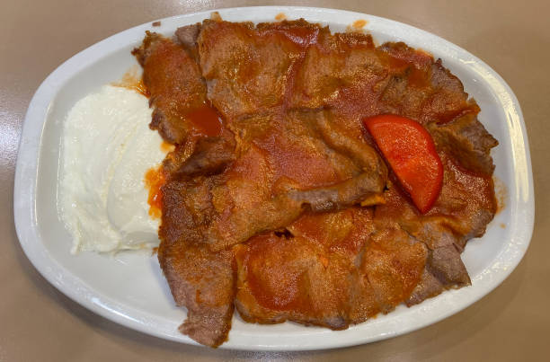 istock Traditional turkish iskender kebab on white plate with yogurt, tomatoes and melted butter 2022581546