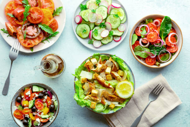 Fresh salads, overhead flat lay shot of an assortment. Variety of plates Fresh salads, overhead flat lay shot of an assortment. Variety of plates and bowls with green vegetables. Healthy food, top shot, with olive oil spring mix lettuce leaves stock pictures, royalty-free photos & images