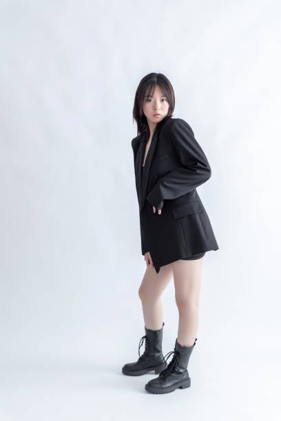 istock Asian young woman in black suit and boots posing in studio 2022619377
