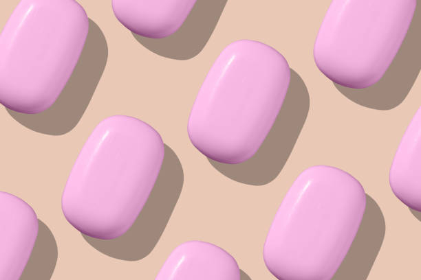 A group of pink toilet soap forming a pattern on a beige background. Top view.