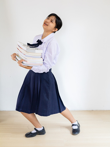 Student young girl carry many book on her arm, White background.