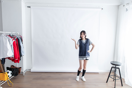 Asian young woman in casual clothes posing in front of white background