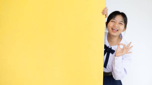 jeune fille étudiante heureuse avec un panneau d’affichage jaune. - billbord photos et images de collection