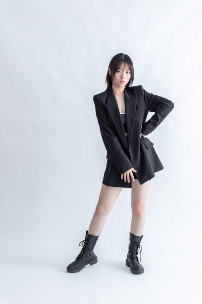 istock Asian woman in black suit and boots posing on white background 2022641613