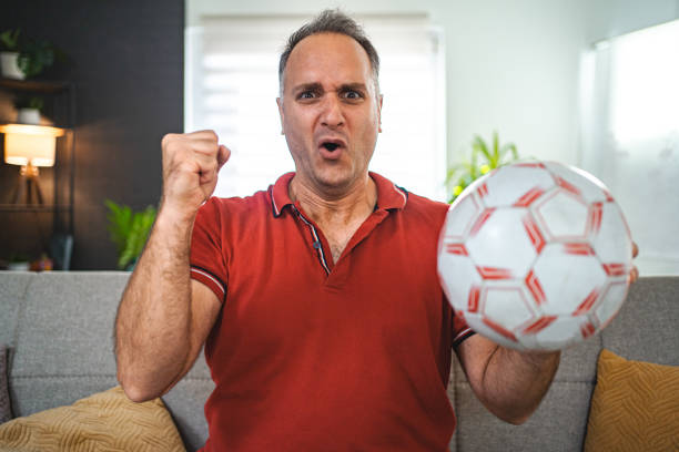 istock Worried middle aged man watching soccer game at home 2022642781