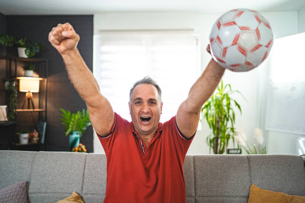 istock Excited middle aged man watching soccer game at home 2022642803