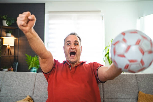 istock Excited middle aged man watching soccer game at home 2022643358