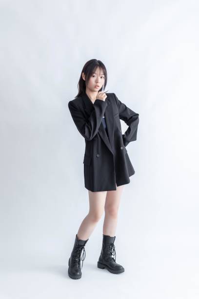 istock Asian woman in black suit and boots posing on white background 2022651384