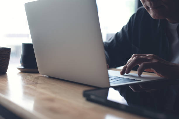 istock Man working at home, typing and searching data on laptop computer on office table. Freelancer at work. Casual business, online job, telecommuting concept 2022660696