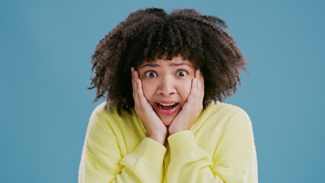 Crazy, news and woman with surprise on face from announcement in blue background of studio. Wow, emoji and portrait of shocked girl excited by secret drama, gossip or hearing rumor information