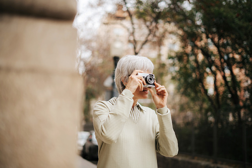 Mature woman taking pictures with vintage camera