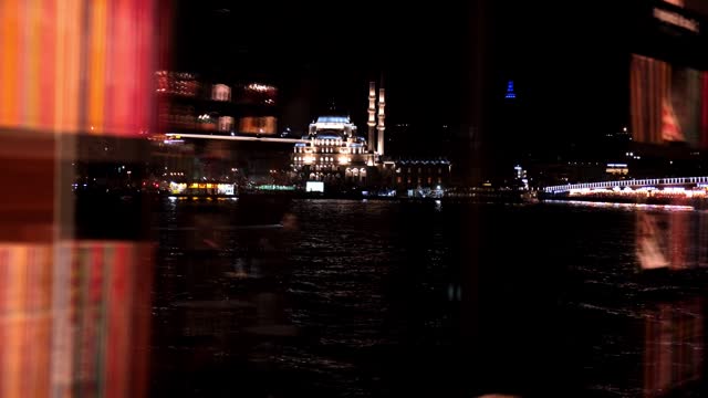The New Mosque and The Galata Bridge in Istanbul and abstract reflections on a cafe window at night
