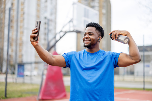 The portrait vividly captures an African American young man in a spontaneous expression of happiness, his infectious smile and bright eyes conveying a deep sense of joy and excitement