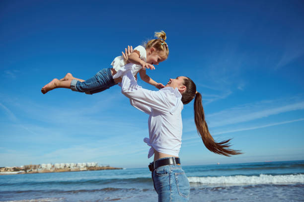 istock Mom and daughter playing on the beach together 2022700799