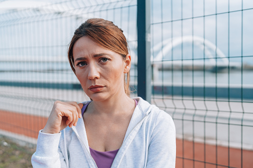 This portrait captures a mid-adult Caucasian woman as worry and sadness cloud her features, her eyes reflecting the turmoil of her emotions, a poignant blend of concern and melancholy marking her expression