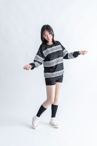 Asian woman in striped top and shorts dancing