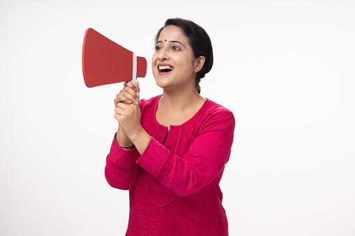 Confident ambitious young Indian businessman shouting in loud speaker, isolated on white