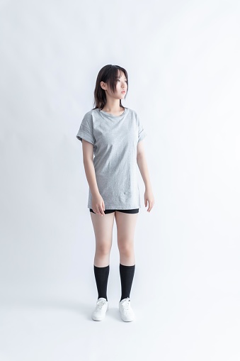 Young Asian woman in gray t-shirt and black shorts standing