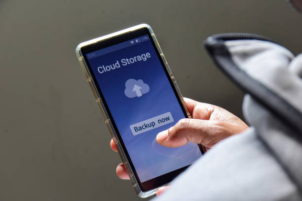 istock Person using online file sharing service to upload and backup files on his mobile phone. 2022711112