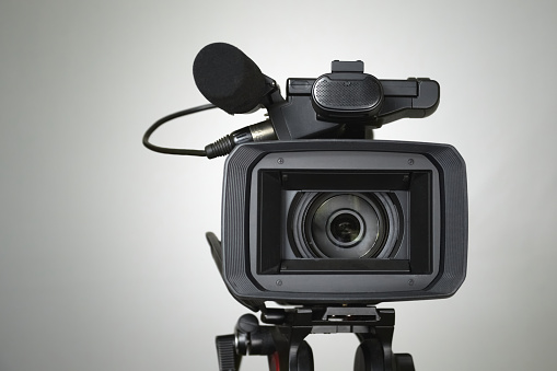 Video camera on a white background with a wide lens, video shooting with a professional camera