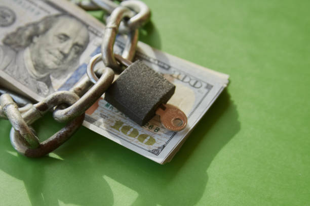 istock Hundred-dollar bills with a chain on them and a closed lock, blocking funds, blocked money, account blocking 2022712796