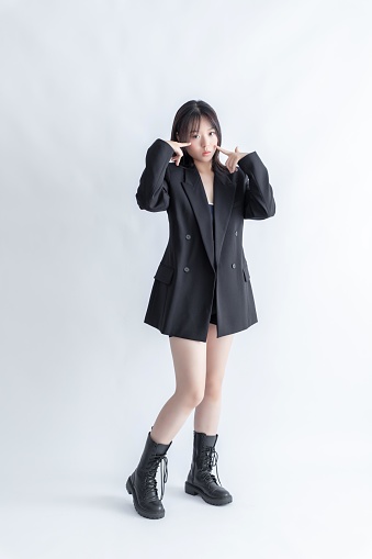 Asian woman in black suit and boots