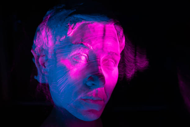 Close up of a bronze head of an important citizen, displayed on a white square stand, visitors in blurred background.
