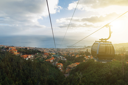 Beautiful landscape of the city of Funchal with the ocean at sunset. Cable car ride above the city on the island of Madeira.