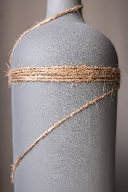 una botella de vino pintada de gris y decorada con cuerda de yute - glue bottle isolated art and craft fotografías e imágenes de stock