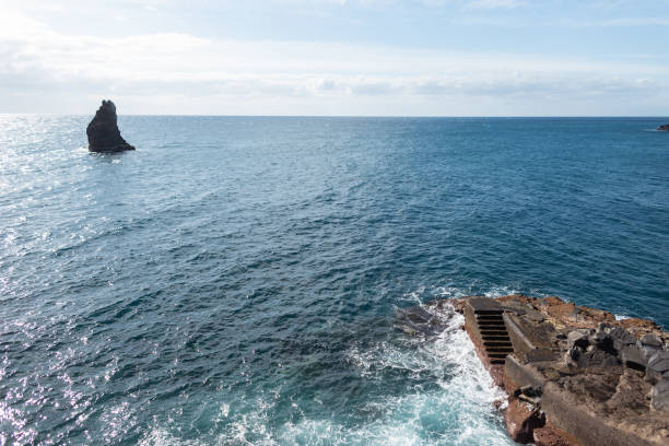 Amazing ocean with blue sky, cliff, rock and steps in Madeira island