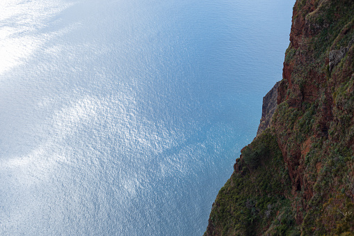 Blue ocean and cliff rock mountion on the island of Madeira from above