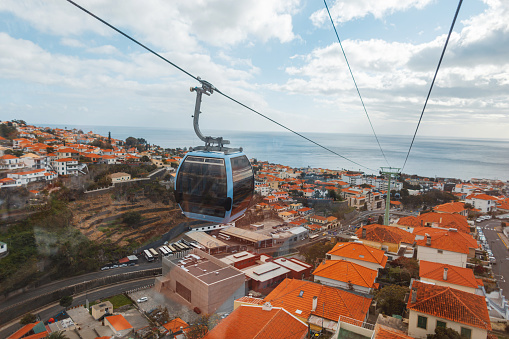 Amazing city of Funchal with orange rooftops and cable car by the ocean. Traveling on the island of Madeira