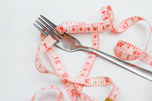istock measuring tape and fork on white background,diet concept 2022783760