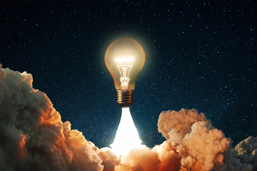 Creative rocket light bulb glows with smoke and blast successfully lift off into the starry sky space. Business start up launch and successful idea, concept. New idea and thoughts. Science