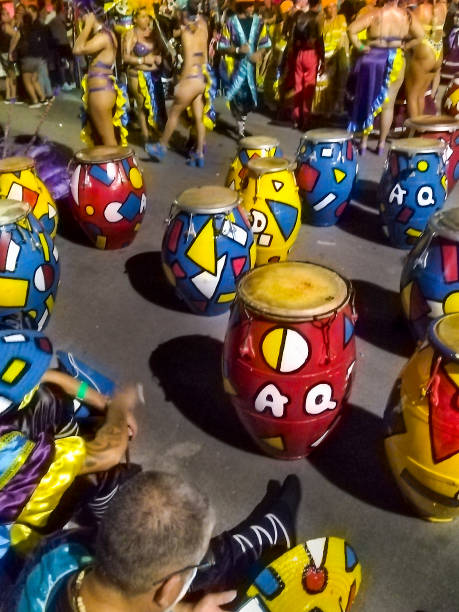 Xanthi, Greece - February 18, 2018: A large drum band performs energetic rhythms in front of a crowd during the annual Xanthi Carnival, with musicians wearing colorful outfits and themed shirts as they march along the parade route near the main stage, entertaining spectators and creating a vibrant atmosphere filled with music, movement, and celebration in the city center