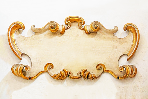 old sculptural plaque with gilded scrolls on the wall. mockup