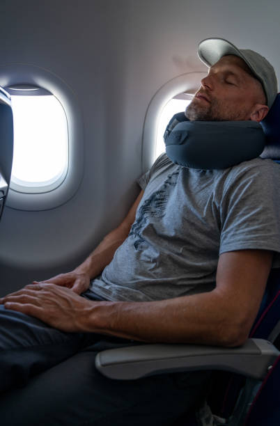 istock A Men is resting with a pillow in plane 2022842503