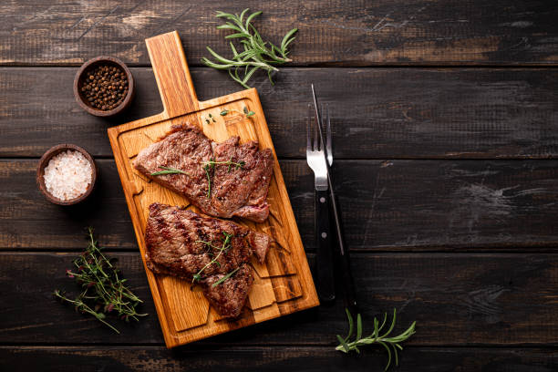 istock Three grilled steaks presented on a wooden cutting board in a rustic setting 2022860432