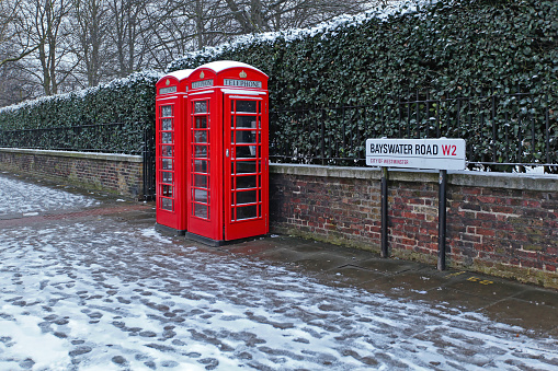 London, United Kingdom - January 18, 2013: Two Red Telephone Boxes at Bayswater Road Covered With Snow Cold Winter Day in Capital City.