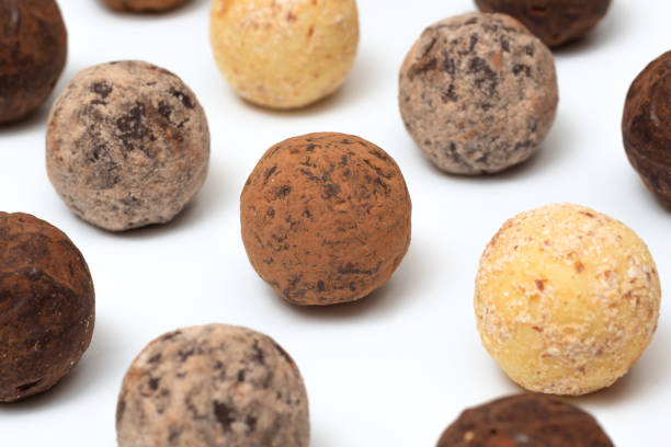 Stock photo showing a display of homemade, individual, luxury chocolate truffles with a ganache centre and coated in a dusting of cocoa powder. These luxury chocolate balls are ideal as a birthday present.