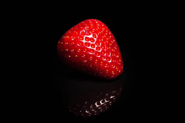 Ripe strawberry on a black background. Organic fruits.