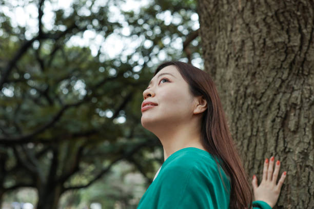 istock Young woman looking up in the forest 2022874330