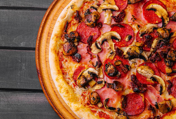 istock Pepperoni pizza with sausage on wood background 2022880333