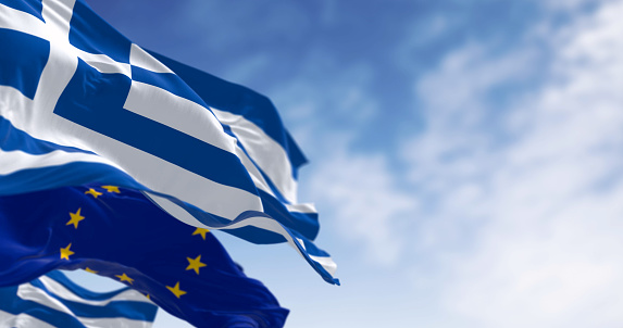 National flags of Greece waving in the wind with flag of the European Union. 3d illustration render. Selective focus. Rippling fabric