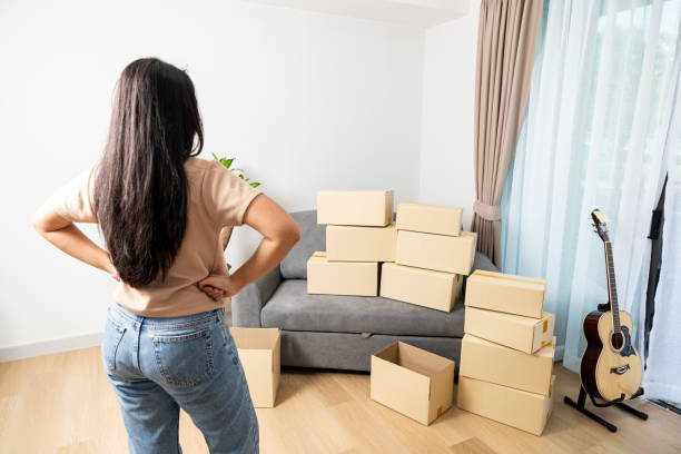 istock young woman with boxes, Moving to a new home. 2022891715
