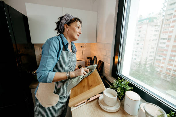 istock Woman washes dishes in a home kitchen. 2022910537