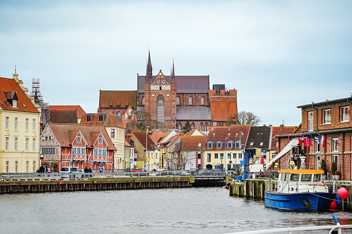 Harbor in the old town of the hanseatic city of Wismar, view on historic houses and the red-brick Georg church, travel destination and tourist magnet at the Baltic sea in Germany, copy space