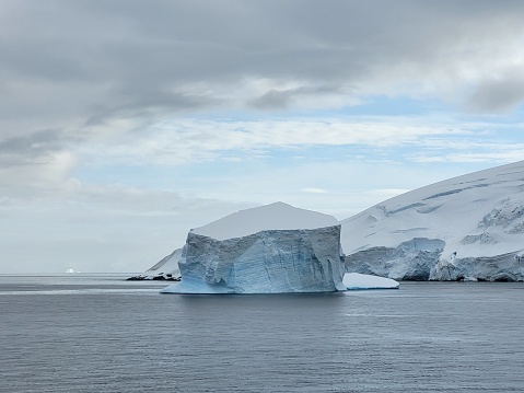 Antarctica continent, hundred shades of blue and reflections of the icebergs, Paradise bay, sunny day, glaciers